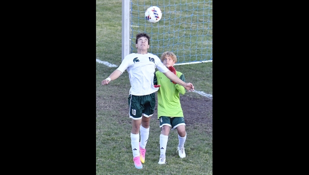ALEX RIVARD (#10, right) heads the ball away from the Spartan goal as keeper Levi Ellison looks on during the second half of the District loss to Roscommon last week.