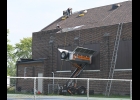 WORKERS FINISH UP the sloped portion of the roof of the Pinconning Community Center on a last week. --Journal Photo