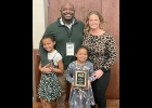 ISAIAH THOMAS, Pinconning Middle/High School teacher, youth wrestling coach, and Linwood resident, was recently presented with the Michigan Wrestling Association 2023 Media Person of the Year Award for his “Coach T Podcast”. He’s shown with his wife Katie and daughters Mari and Everest. --Courtesy Photo